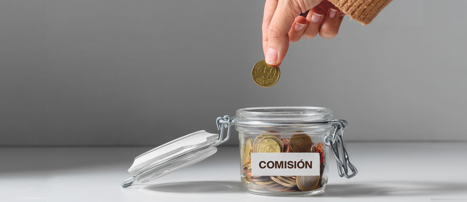 Recuerda: un agente de verdad nunca te pedirá dinero por adelantado, solo cobra una comisión del éxito. Bote de monedas que representa la comisión del agente literario, un porcentaje de los ingresos del autor.