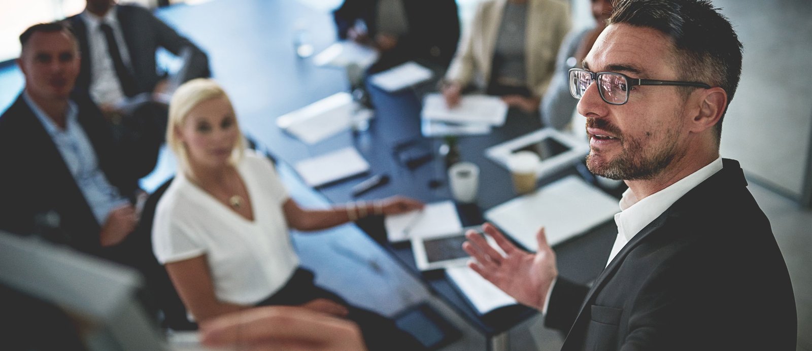 Para que tu obra llegue a esta mesa, debe superar antes varios filtros de calidad y viabilidad comercial. El filtro definitivo es el comité editorial. Un comité editorial en plena reunión, deliberando con documentos sobre la mesa de trabajo.