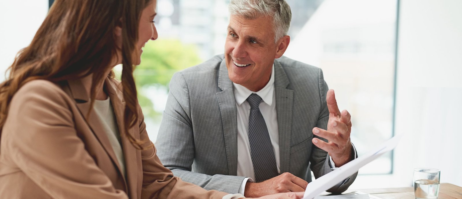 Una autora recibiendo asesoramiento legal de su abogado especializado en propiedad intelectual sobre un contrato de derechos audiovisuales
