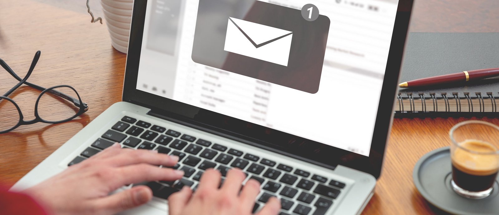 Primer plano de la pantalla de un ordenador mostrando la bandeja de entrada de un email, simbolizando el envío del paquete editorial a un editor o agente.