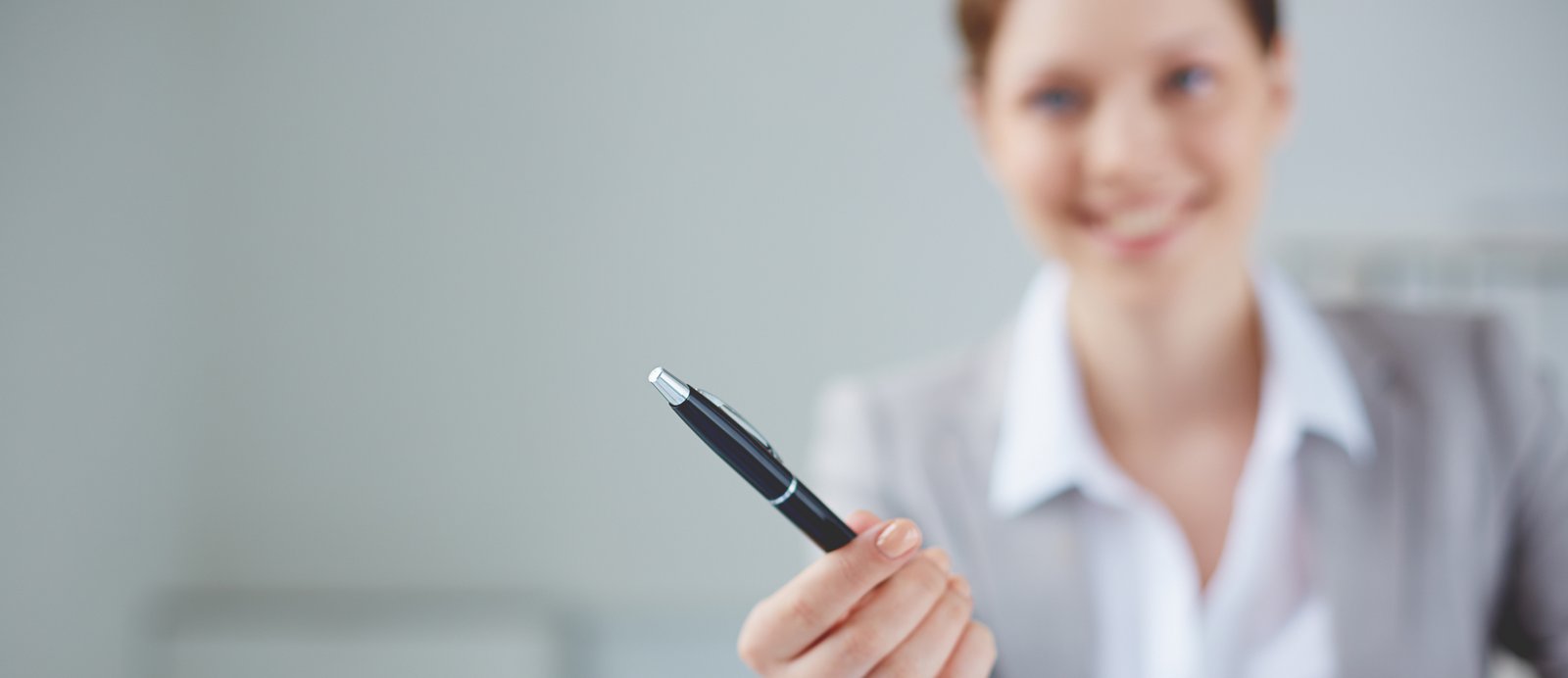 Antes de aceptar el bolígrafo y firmar, asegúrate de haber entendido cada línea del acuerdo. Agente literario ofreciendo un bolígrafo al autor para la firma del contrato de representación.