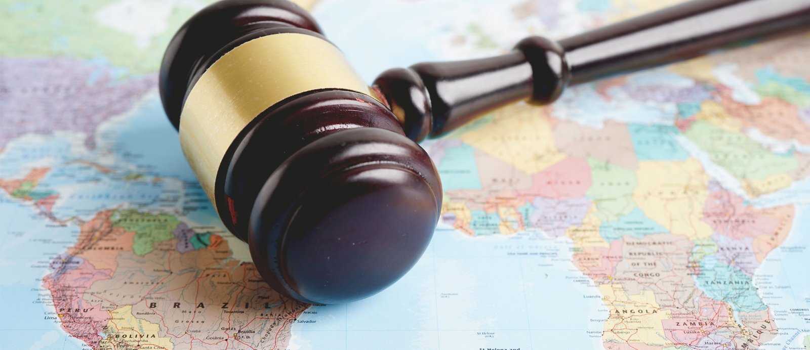 Un mazo de juez sobre un mapa del mundo, representando cómo el Convenio de Berna otorga protección legal internacional a los derechos de autor.
