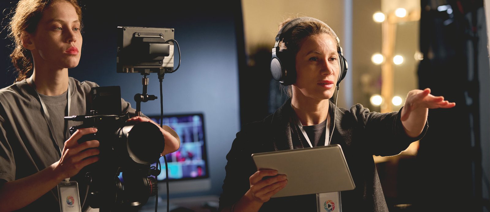 Un director, siguiendo la visión del productor audiovisual, da indicaciones a un cámara en un set de rodaje para transformar la obra literaria en una producción audiovisual.