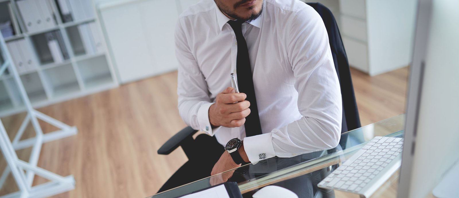 Editor frente al ordenador, leyendo y evaluando la calidad y el valor comercial de un manuscrito.