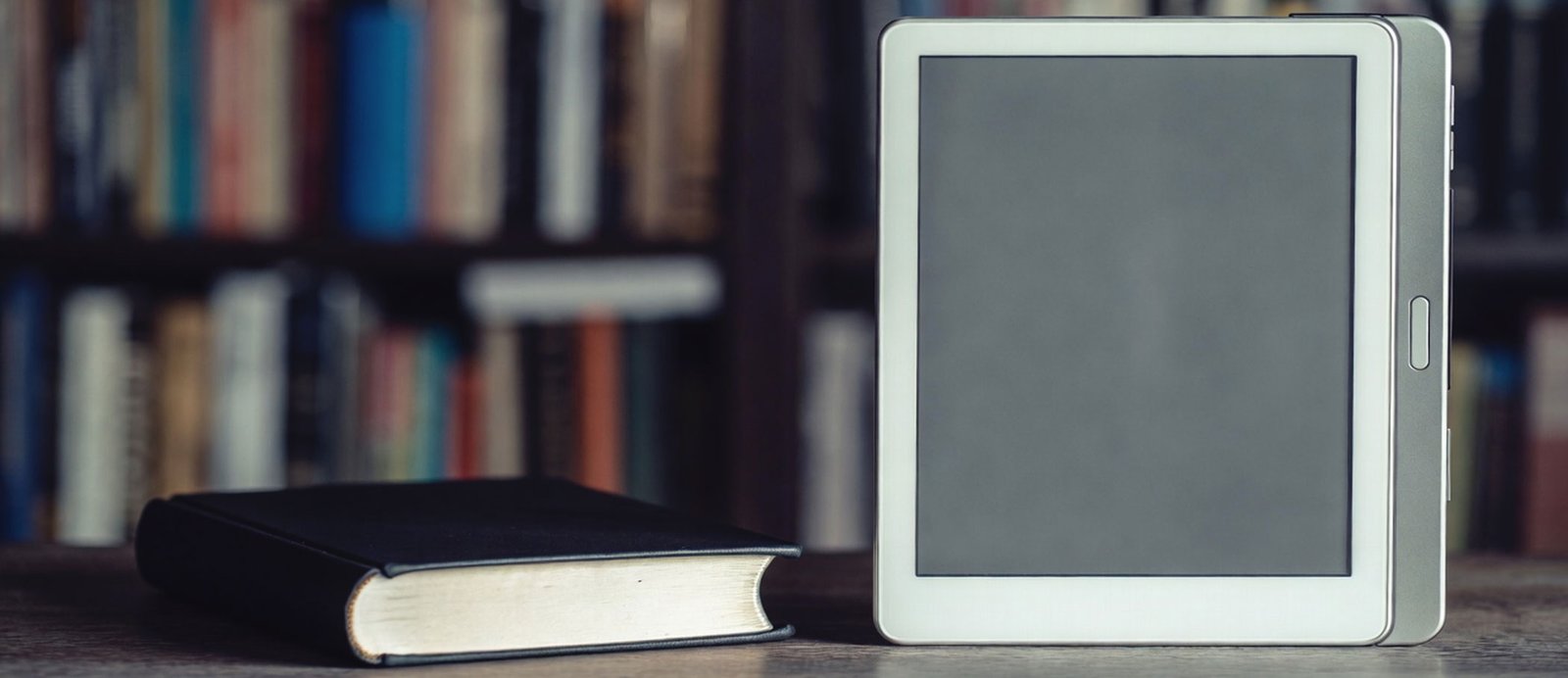 Imagen de unos libros físicos conectados por cable a un móvil o e-reader.