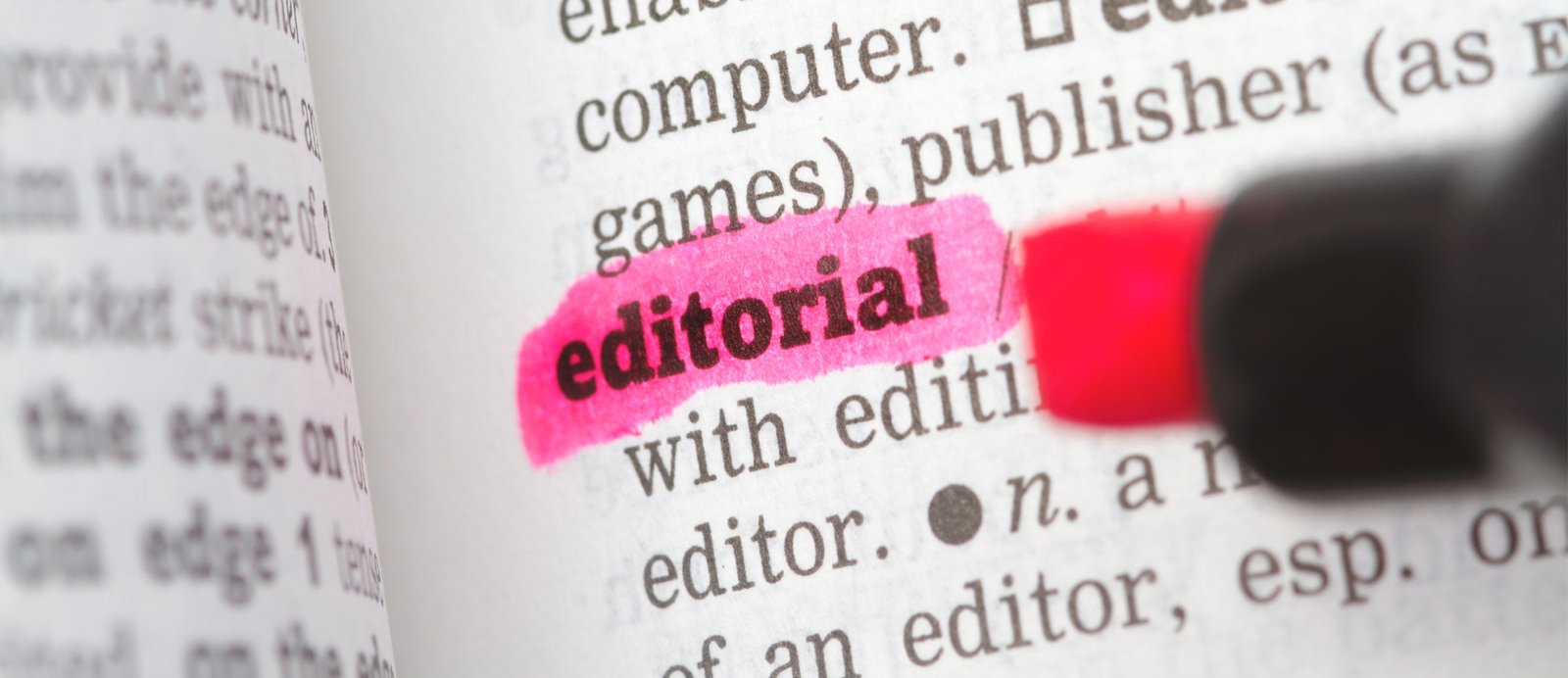 Rotulador fluorescente subrayando la palabra editorial: el primer paso para publicar novela o ensayo en España.