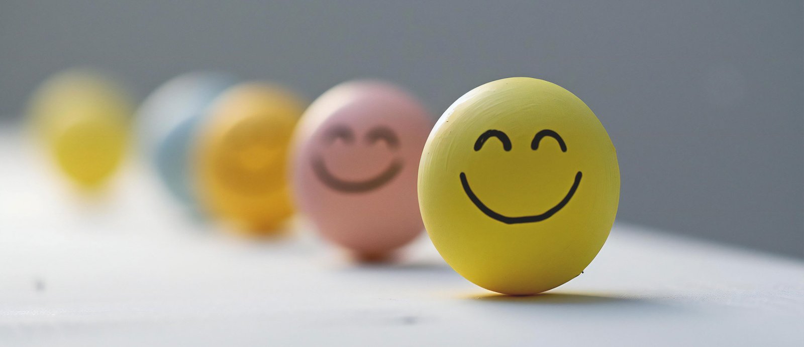 Bloque de madera con una cara sonriente pintada, representando la satisfacción y el 'engagement' de un lector con un libro.