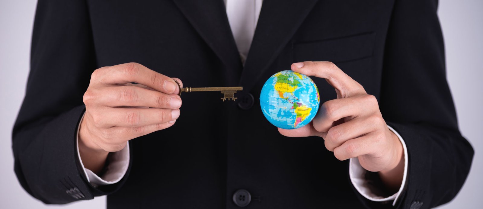 Las ferias internacionales son la llave para vender los derechos de tu obra en todo el mundo. Ilustración de un hombre sosteniendo una llave en una mano y una bola del mundo en la otra, simbolizando el acceso a los mercados internacionales a través de las ferias del libro.