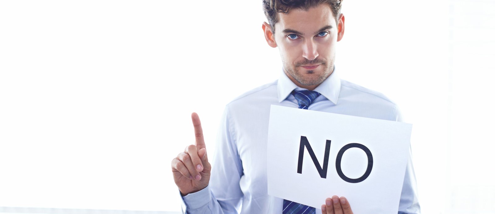 Un editor sosteniendo un cartel de 'NO', simbolizando las barreras y el rechazo de la industria tradicional hacia los autores autoeditados.