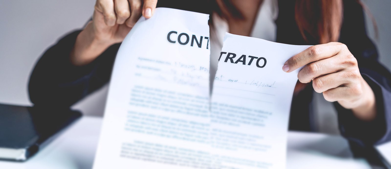 Mujer rompiendo el documento legal para finalizar la relación editorial y recuperar los derechos de explotación.