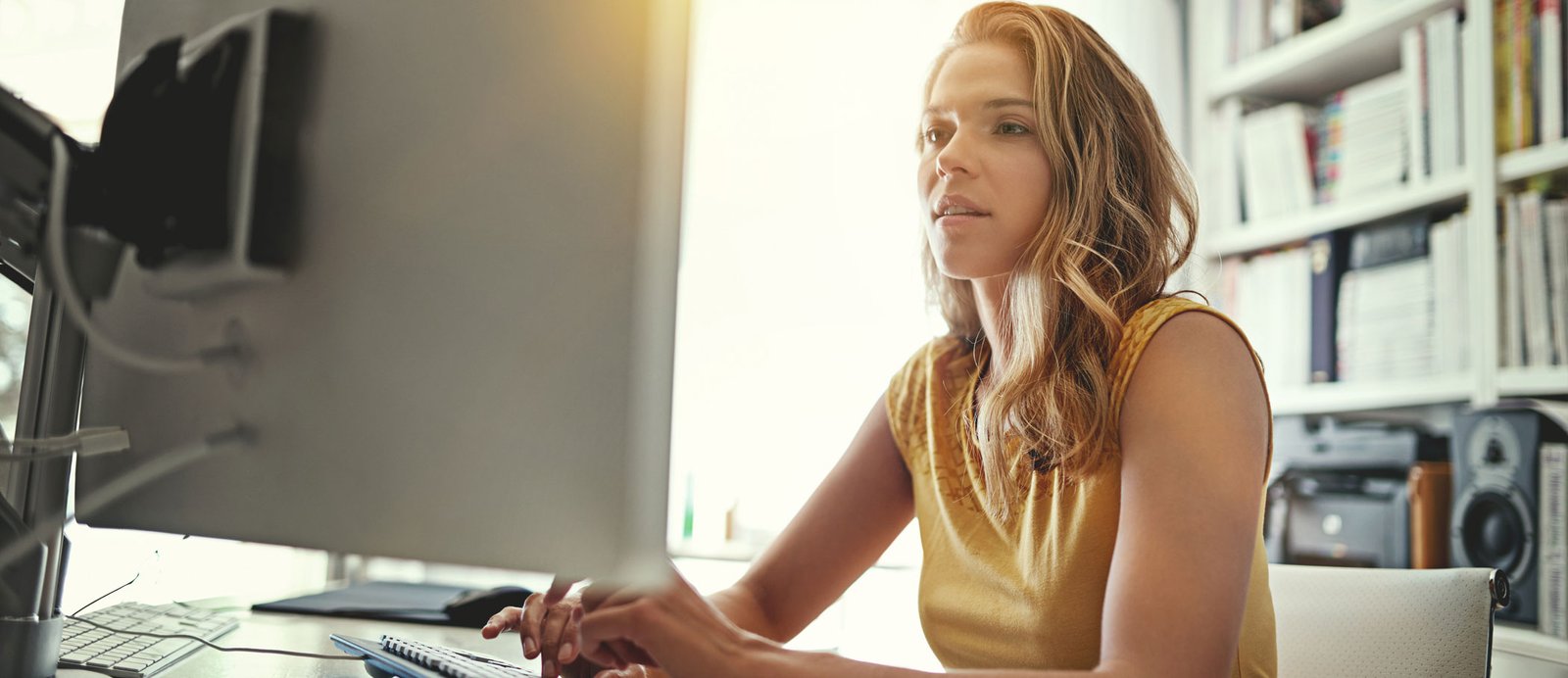 Escritora trabajando en el ordenador para gestionar la autopublicación de su obra recuperada y subir los nuevos archivos a Amazon KDP.