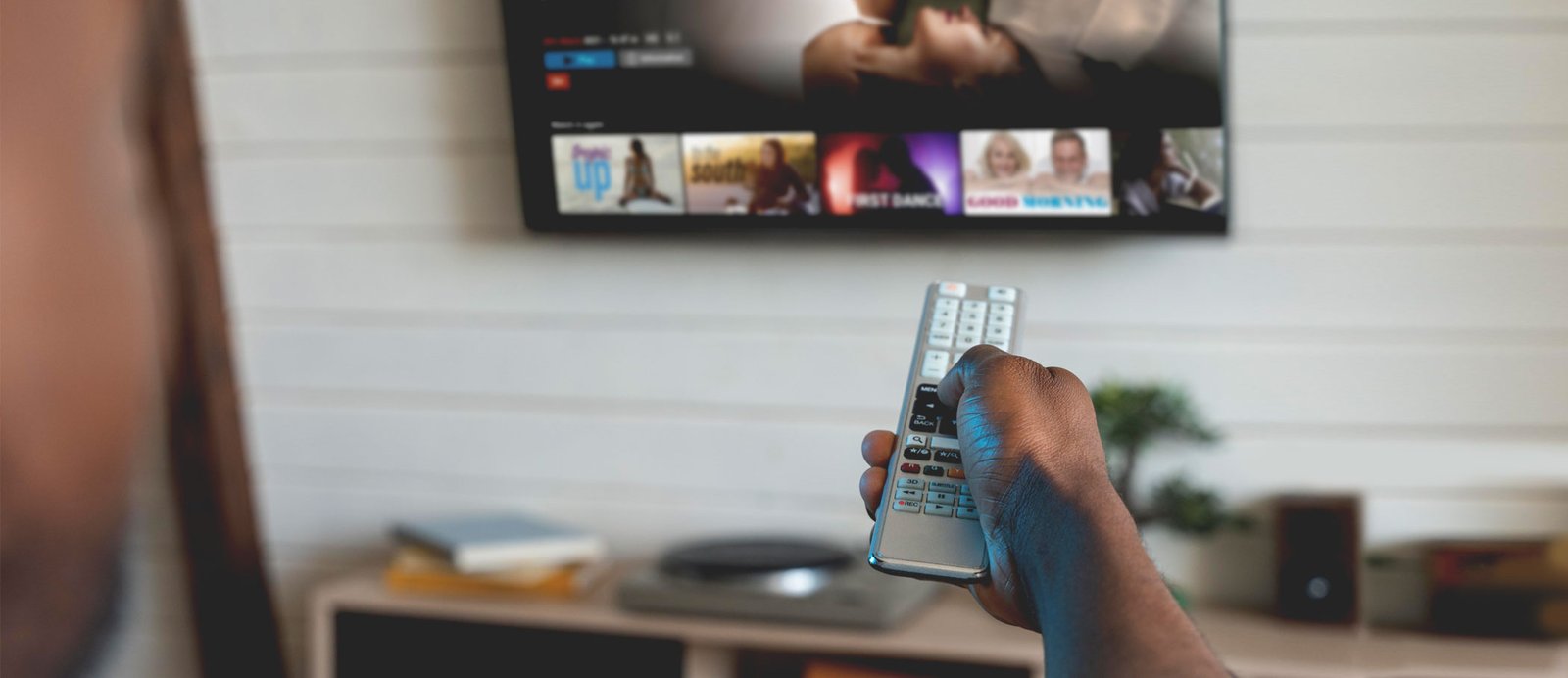 Un espectador eligiendo una serie en una plataforma de streaming, ilustrando el actual panorama de consumo audiovisual y la importancia de negociar las condiciones de explotación de los derechos.